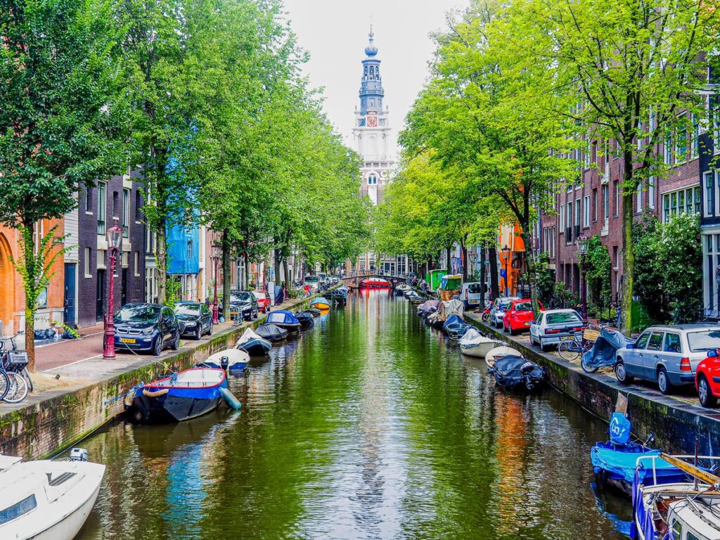 Zuiderkerk tower and picturesque Amsterdam canal view with historic buildings and boats