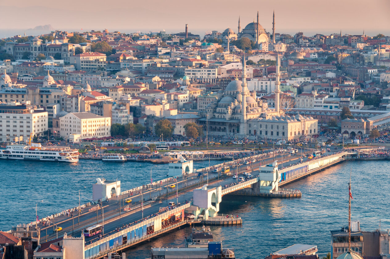 Istanbul Galata Bridge sunset over historic center with Bosphorus, mosques and minarets.