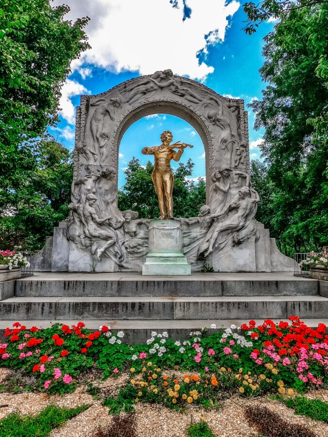 Golden Johann Strauss II statue with roses in Vienna's Stadtpark