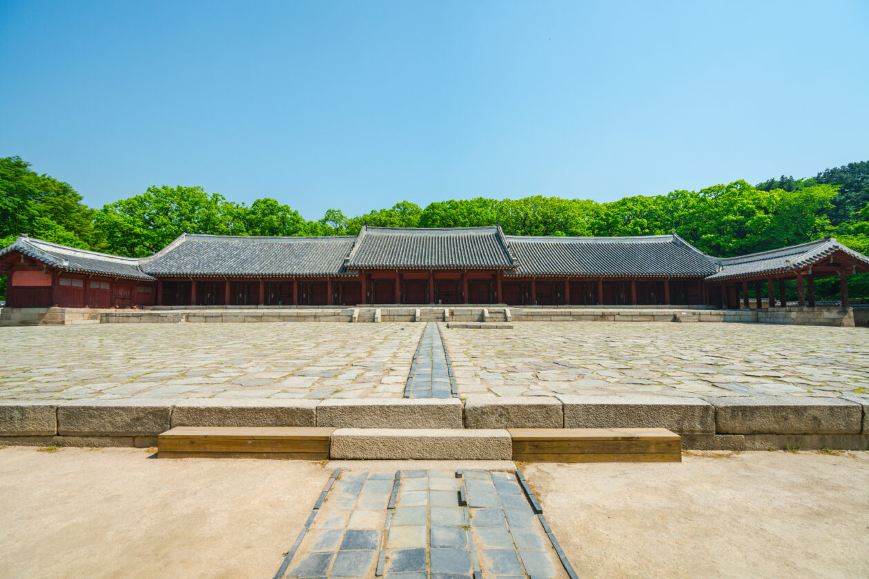 Jongmyo Shrine in Seoul featuring traditional Korean architecture, stone courtyard, and lush surrounding trees.
