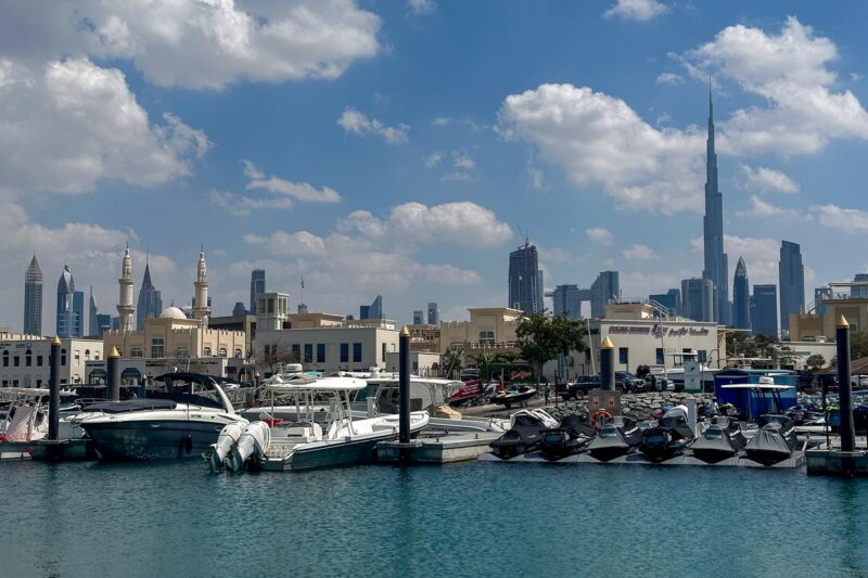 Jumeirah Fishing Harbour with Burj Khalifa skyline and boats.
