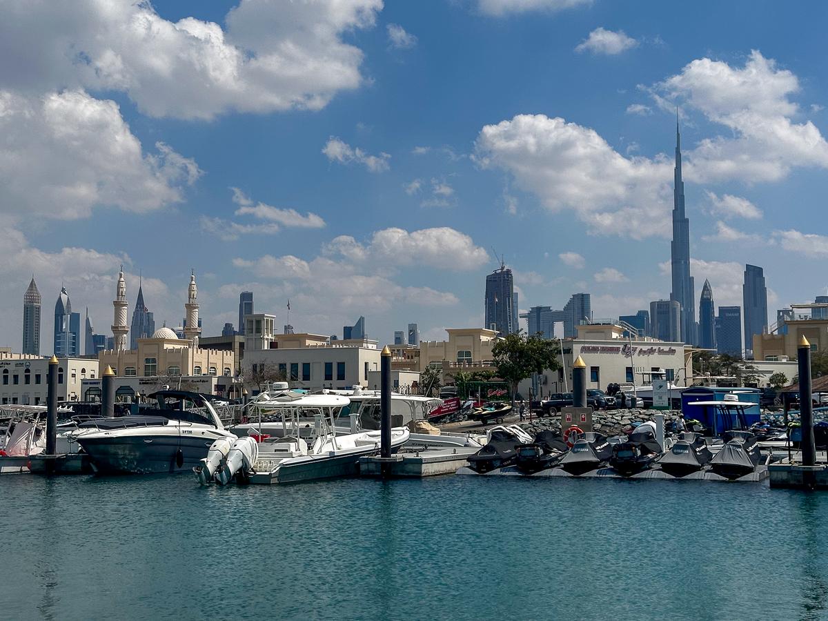 Jumeirah Fishing Harbour with Burj Khalifa skyline and boats.