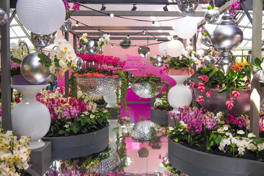 Vibrant indoor floral display at Keukenhof Gardens exhibit with eclectic decor and lush blooms.