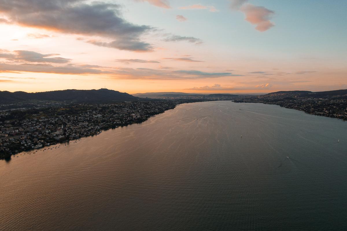 Stunning aerial sunset view of Lake Zurich with hills and scattered boats, zurich aerial view