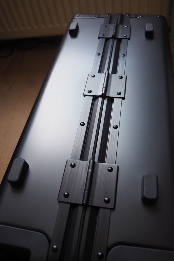 A close view shows the LEVEL8 Gibraltar metal hinge, rivets, and protective feet.