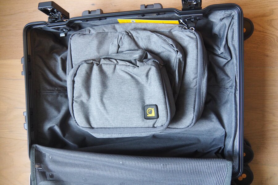 A grey packing bag rests inside one half of the open LEVEL8 Gibraltar carry-on.