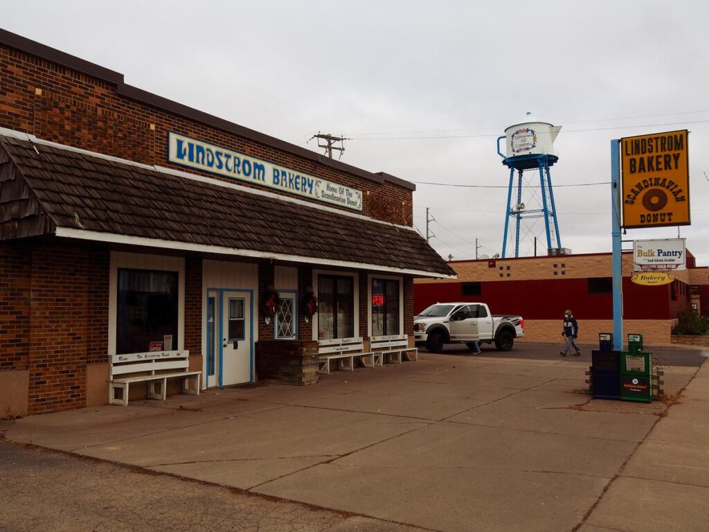 Lindstrom Bakery: Home of the Scandinavian Donut, nestled in Lindstrom, MN, with a Swedish coffee pot water tower in the background.