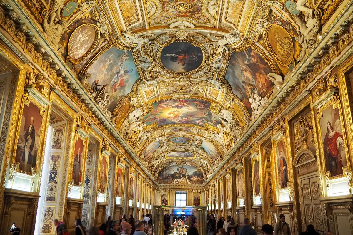 Opulent Louvre Museum gallery in Paris with golden accents and classical art