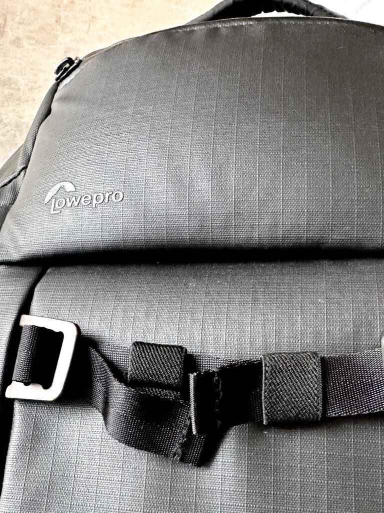 Lowepro Freeline BP 350 AW Review, a camera backpack with secure buckle on textured surface