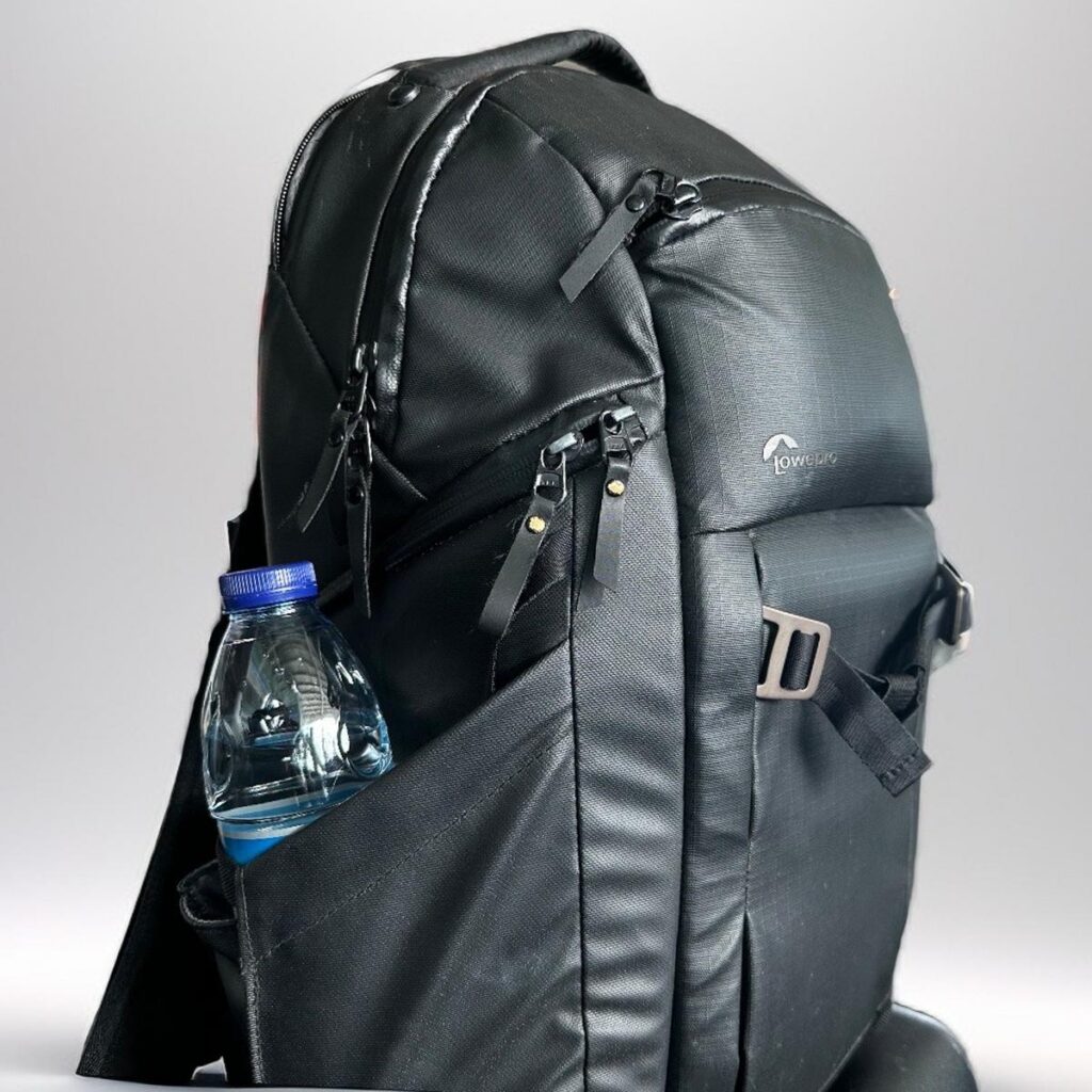 A black Lowepro FreeLine camera backpack with water bottle, showcasing durability and practical design for photographers.