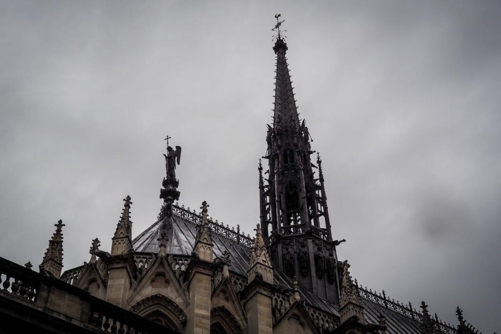 Close-up of Sainte-Chapelle spire under a cloudy sky in Paris