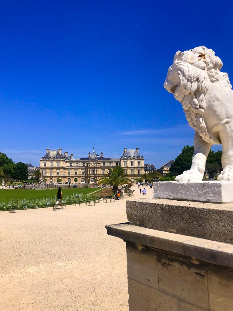 Majestic lion statue overlooking Luxembourg Gardens in Paris.