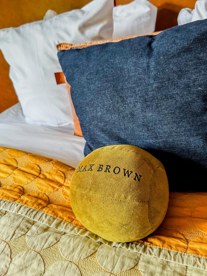 Luxury Max Brown Hotel bedding with logo pillow and quilted coverlet in Amsterdam