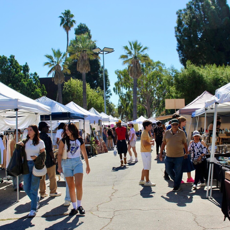 A sunny day with clear skies in the background as visitors walk around the Melrose Trading Post in Los Angeles, California