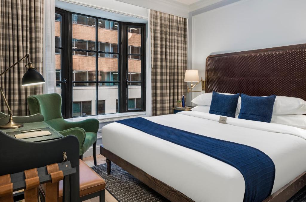 Guest room with dark wood furnishings at Merrion Row Hotel near Times Square