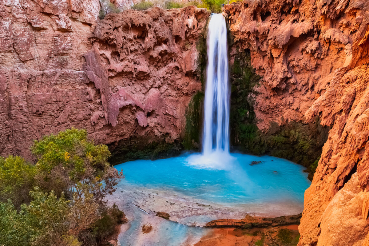 Mooney Falls Arizona turquoise pool in red sandstone canyon with moss waterfall.