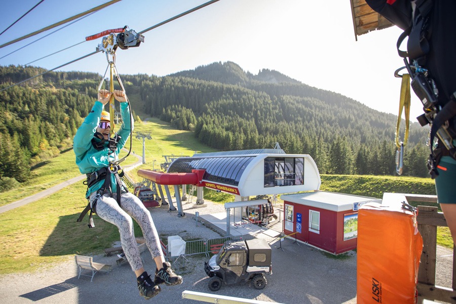 Zip line in Germany gliding above a scenic mountain resort.