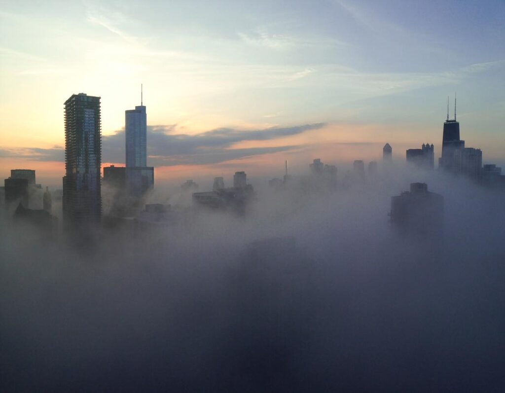 Chicago skyline enveloped in morning fog at dawn.