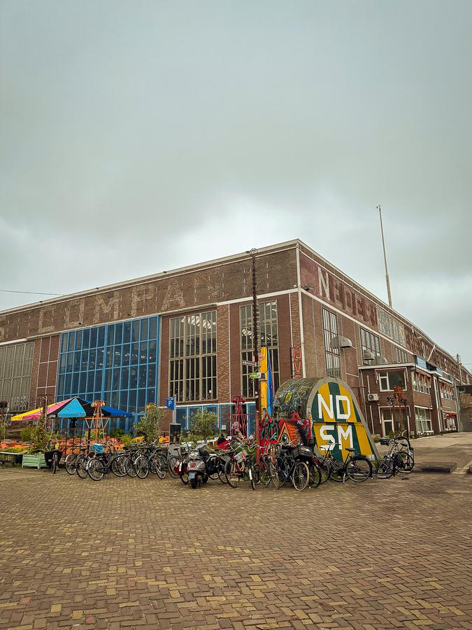 Colorful bikes at NDSM Wharf building entrance in Amsterdam with artistic decor