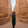 Woman exploring historic temple ruins at sunset
