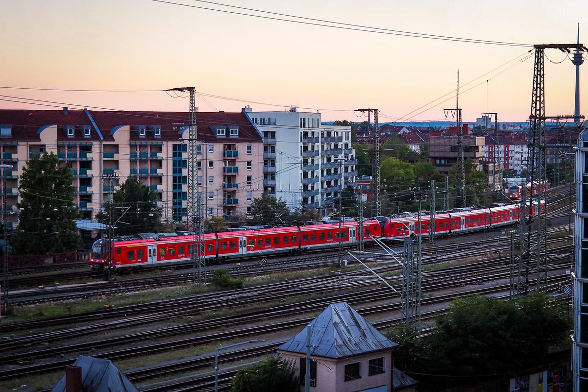 Red commuter train arriving at Nuremberg Station at sunset