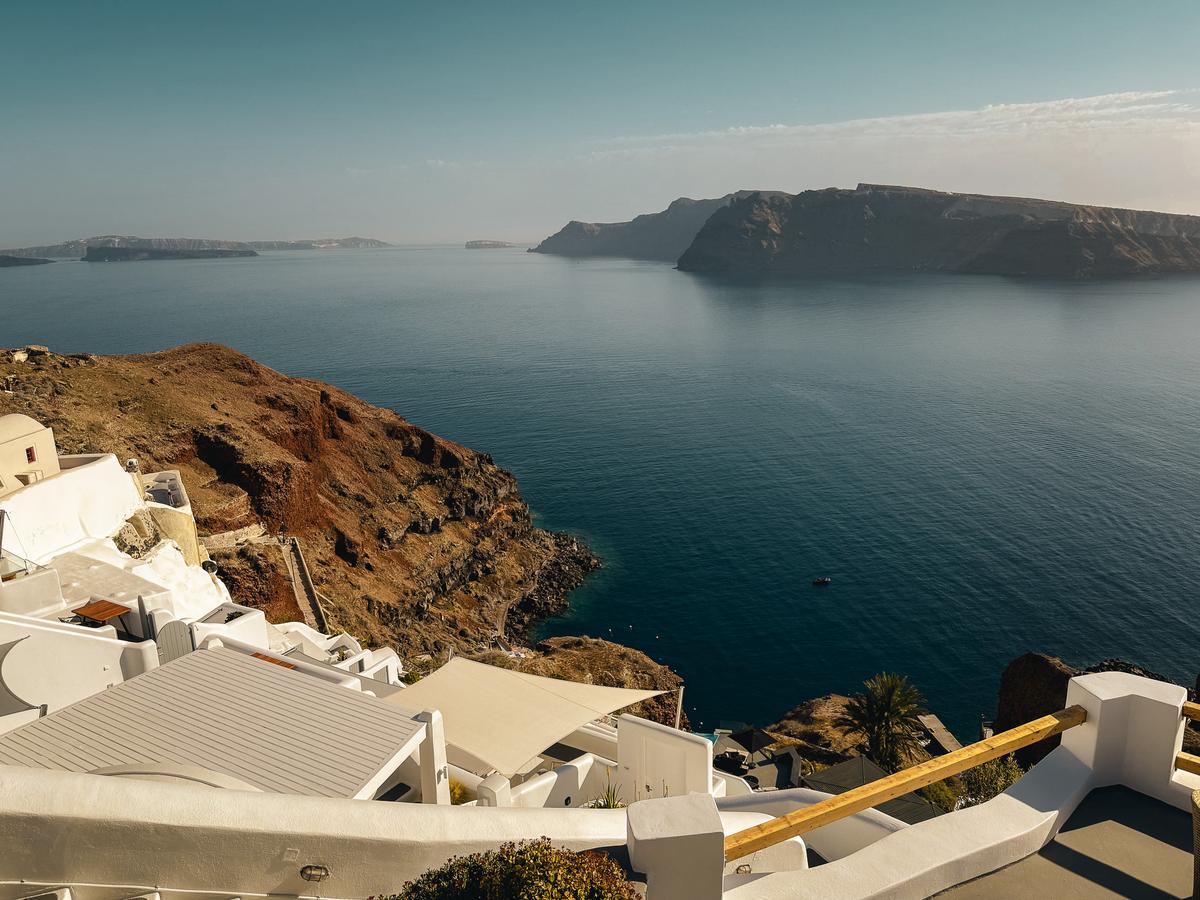 Oia coastline in Santorini, Greece: stunning cliffside views, azure waters, iconic white buildings