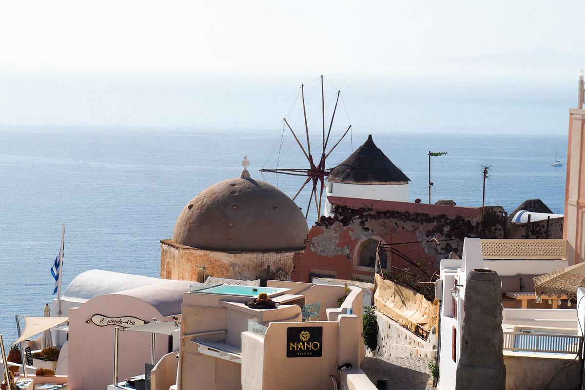 Sunset over Oia Santorini, iconic white-washed architecture and Aegean Sea views