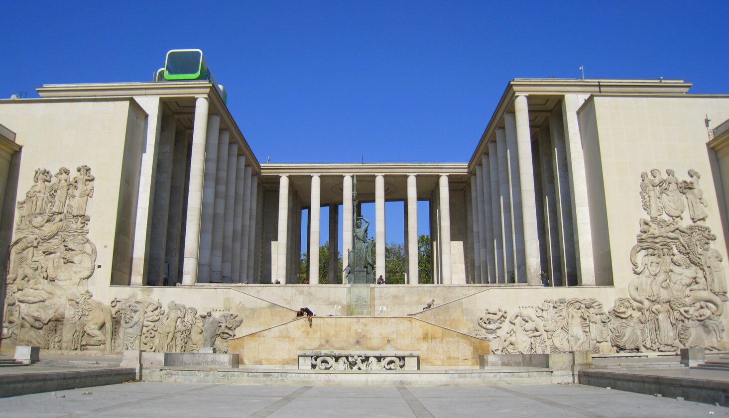 Paris Palais de Tokyo facade featuring neoclassical columns, bas-reliefs, and a modern rooftop sculpture.