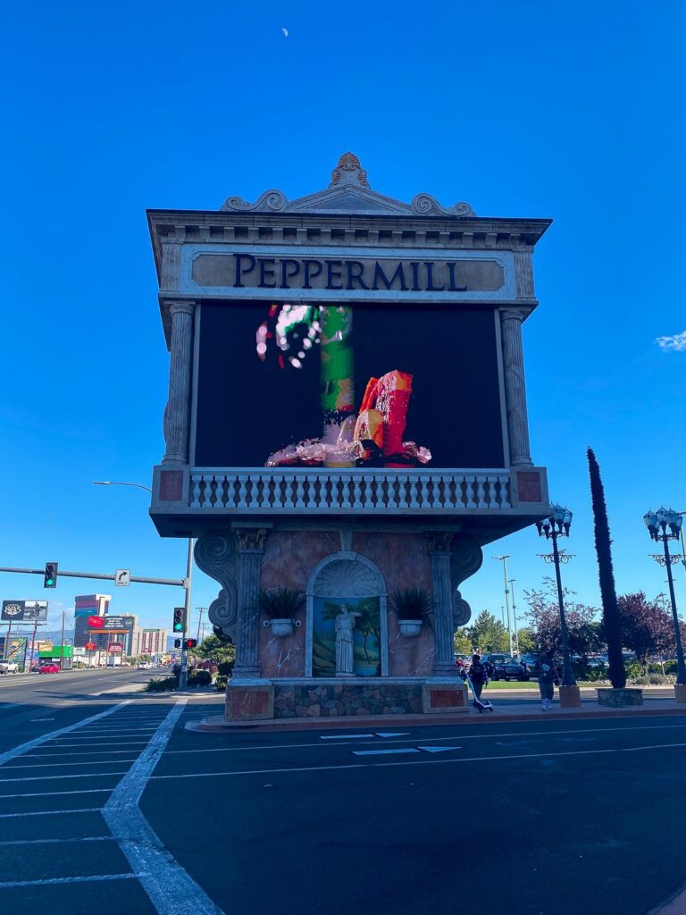 The Peppermill Reno Resort sign with digital display against sunny blue skies