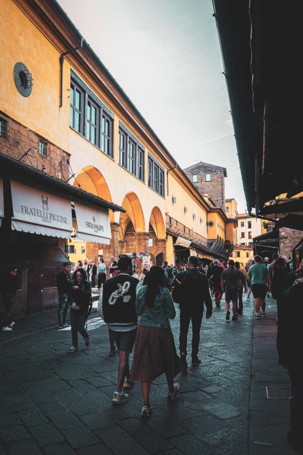High-resolution image of Ponte Vecchio, a medieval stone bridge in Florence, Italy, bustling with vibrant daily life and historic charm