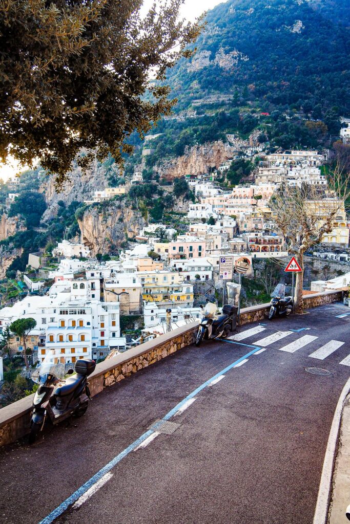 Positano View from Hotel Villa Gabrisa on Amalfi Coast, Italy - Cliffside town with terracotta roofs cascading to the sea, clear blue sky at dusk.