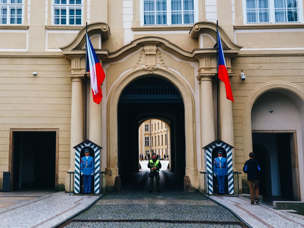 Ceremonial guards at Prague Castle entrance with Czech flag