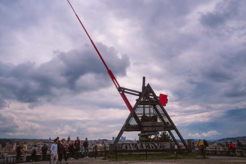 Iconic Prague Metronome against dramatic clouds with tourists