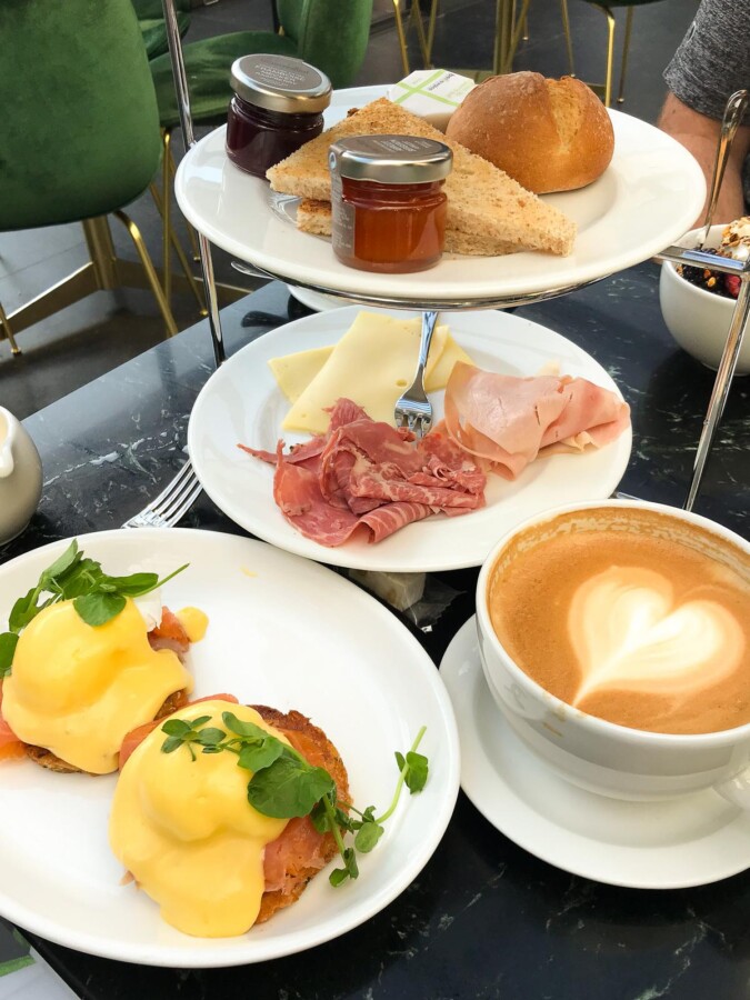 Luxurious breakfast spread with eggs benedict and cappuccino at Pulitzer Amsterdam.