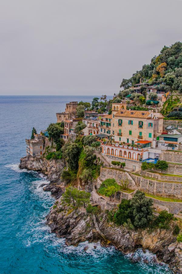 Aerial view of Ravello Art Apartments on cliff overlooking azure sea