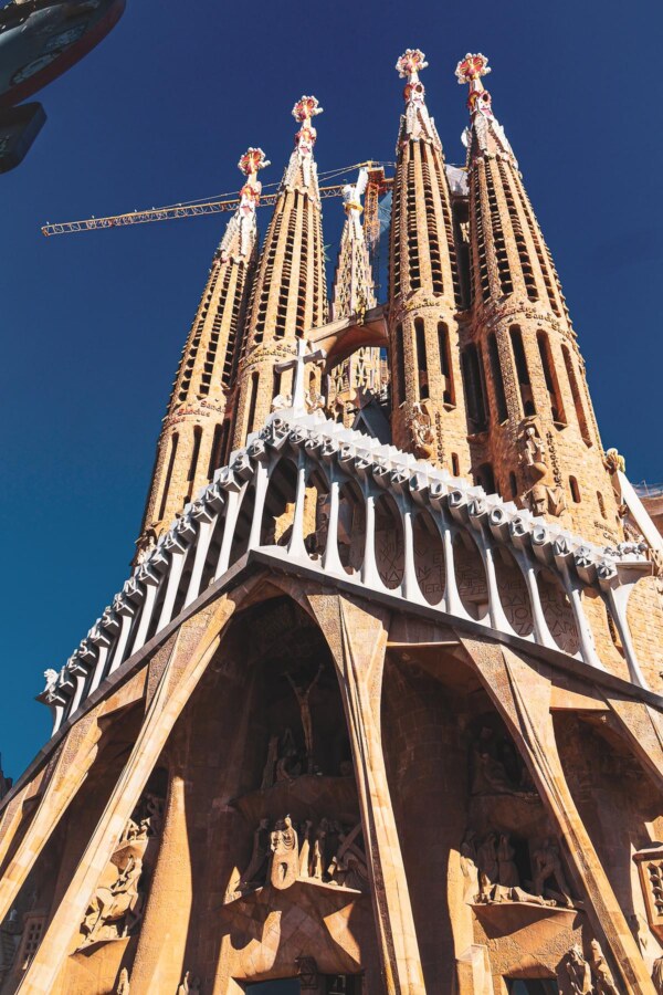 La Sagrada Familia facade with detailed sculptures and construction crane in Barcelona