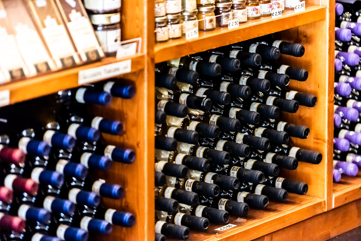 San Gimignano town village in Tuscany during day and wine store with many packaged bottles of local drink called Vernaccia and Chianti