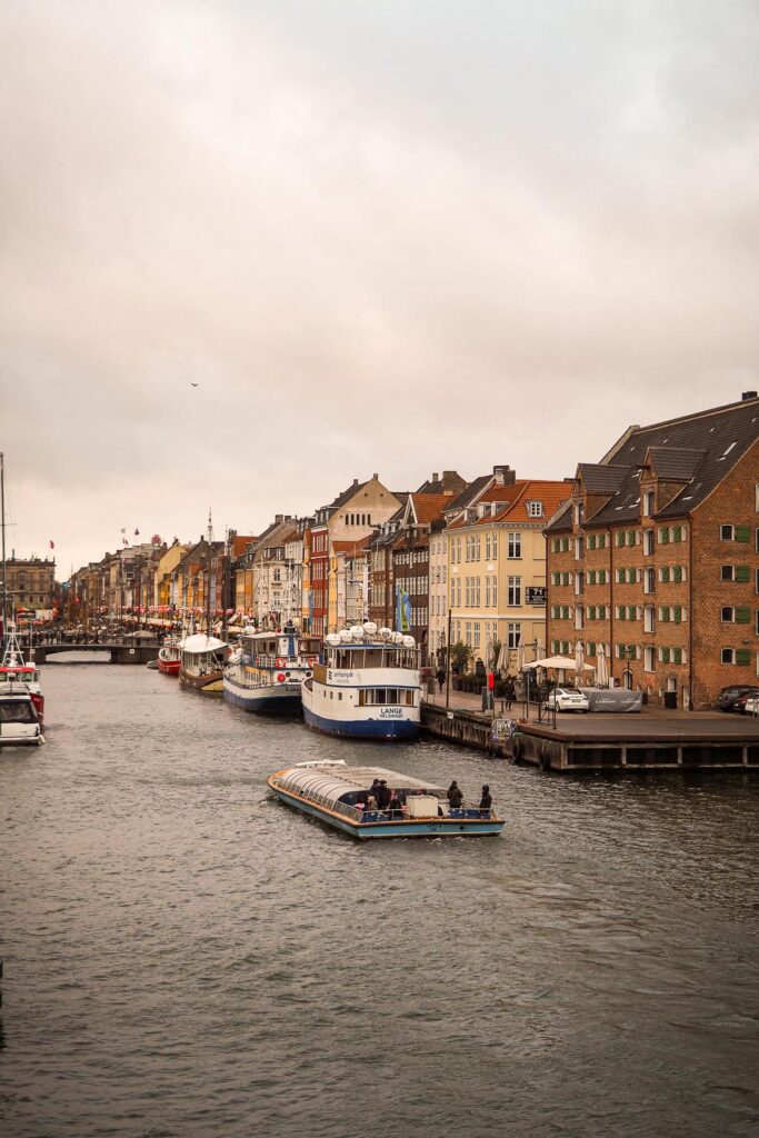 Sightseeing boat cruising through a Copenhagen canal near Nyhavn