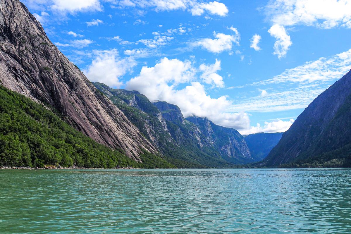 Breathtaking view of Eidfjord's tranquil waters surrounded by towering cliffs in Norway