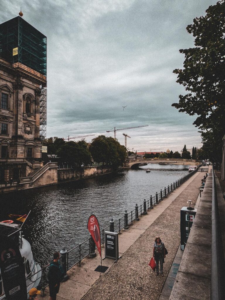 Scenic View of River Spree and Historic Architecture in Berlin, Germany - Tranquil beauty of Berlin's River Spree with historical and modern cityscape, tourists, and river tour boat.