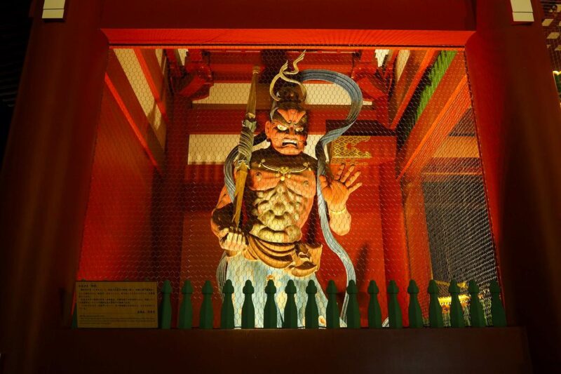 Vibrant Senso-ji Temple Guardian Statue, Tokyo: A striking wooden figure in a richly decorated temple interior.