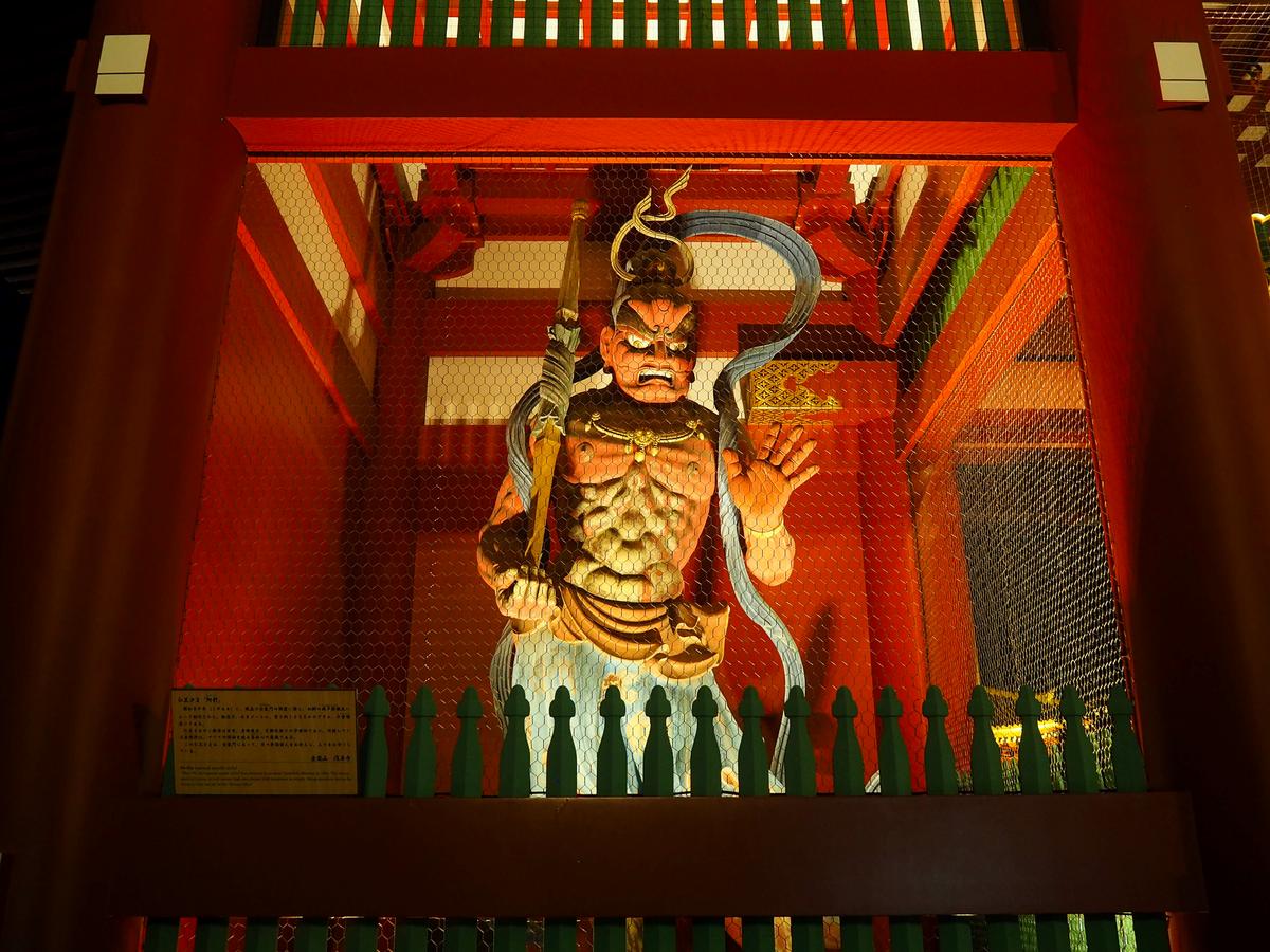 Vibrant Senso-ji Temple Guardian Statue, Tokyo: A striking wooden figure in a richly decorated temple interior.