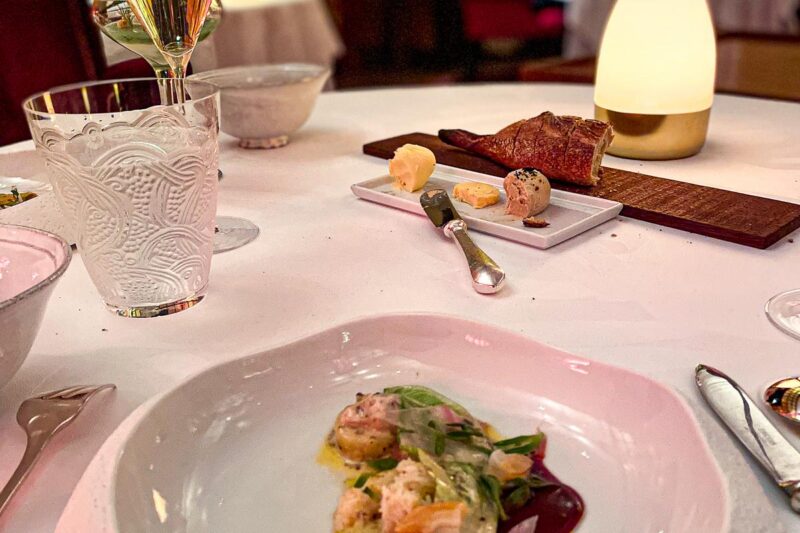 Sketch London gourmet dining experience with seafood entree and white wine in a chic Mayfair restaurant ambiance.