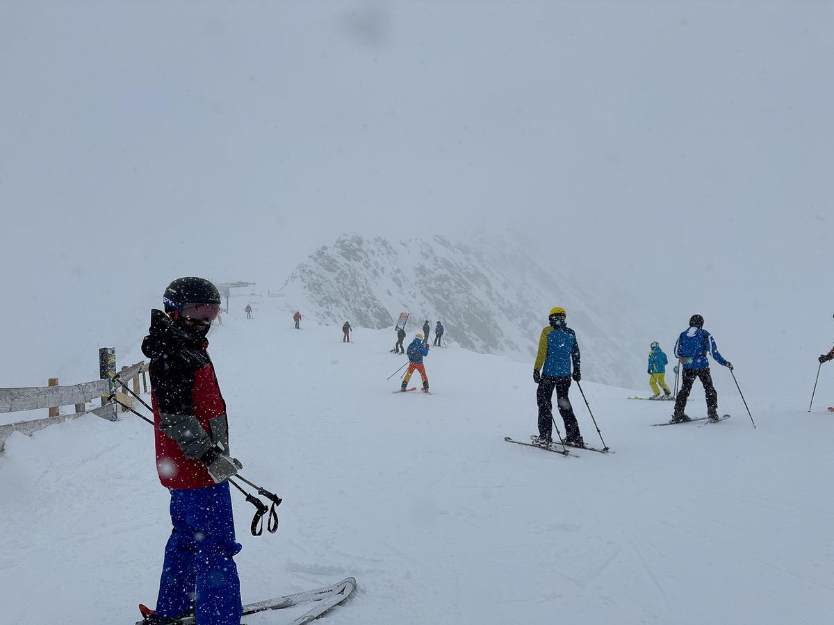 Skiers enjoying fresh snowfall at Stubai Glacier, Austria, during a blizzard.