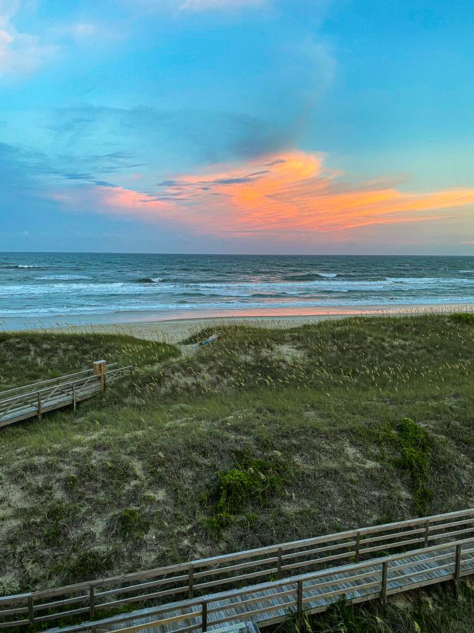 Sunset over Cape Hatteras Beach, North Carolina with vibrant sky colors and serene coastal view.