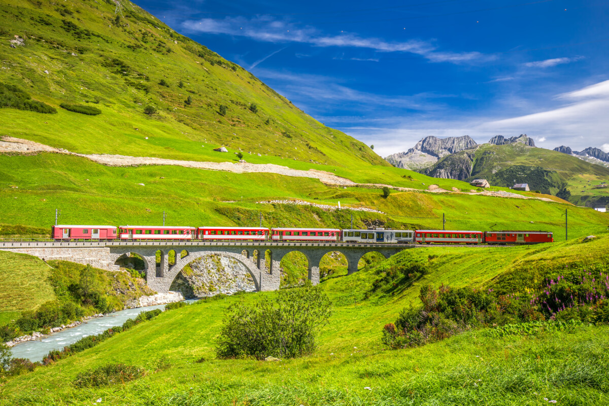 Train on the viaduct bridge and the scenic view of the Swiss Alps in Switzerland