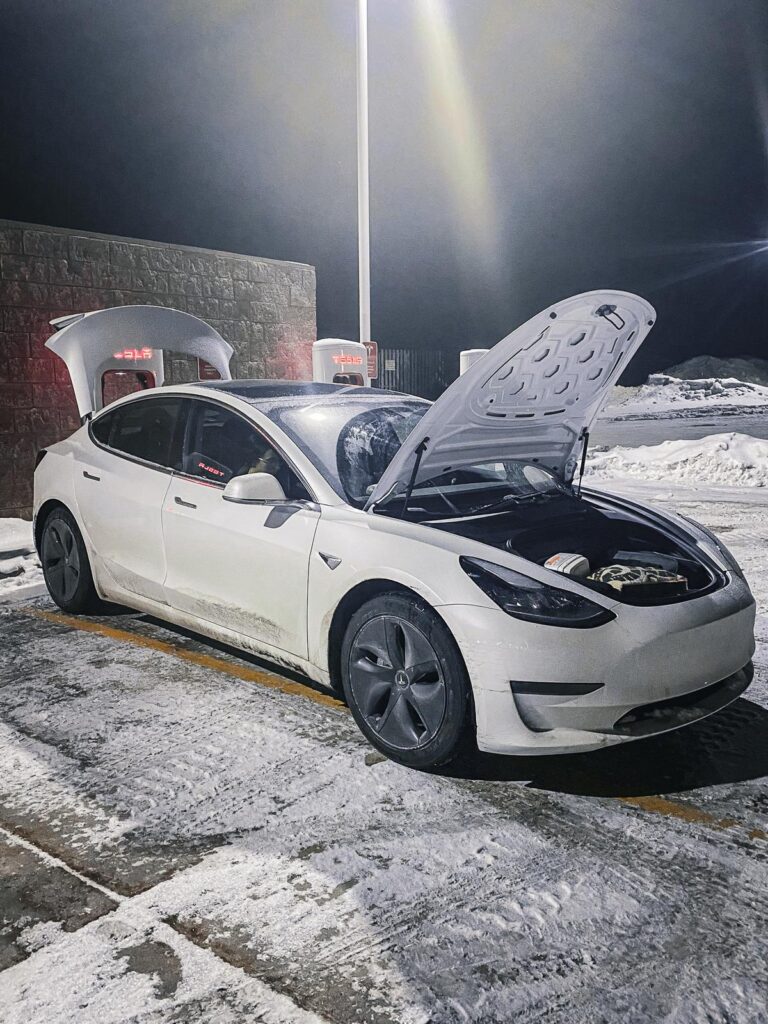 Tesla Model 3 charging at snowy Tesla Supercharger station