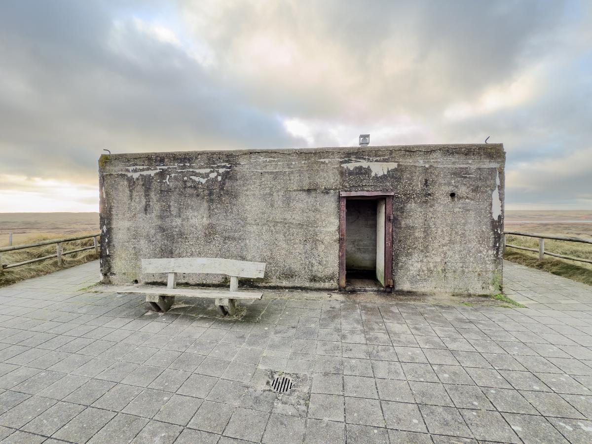 World War II bunker on Texel Island under gray skies, highlighting historic significance and somber reflection.