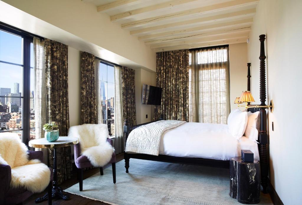 Guest room with hardwood floors and city windows at The Ludlow Hotel