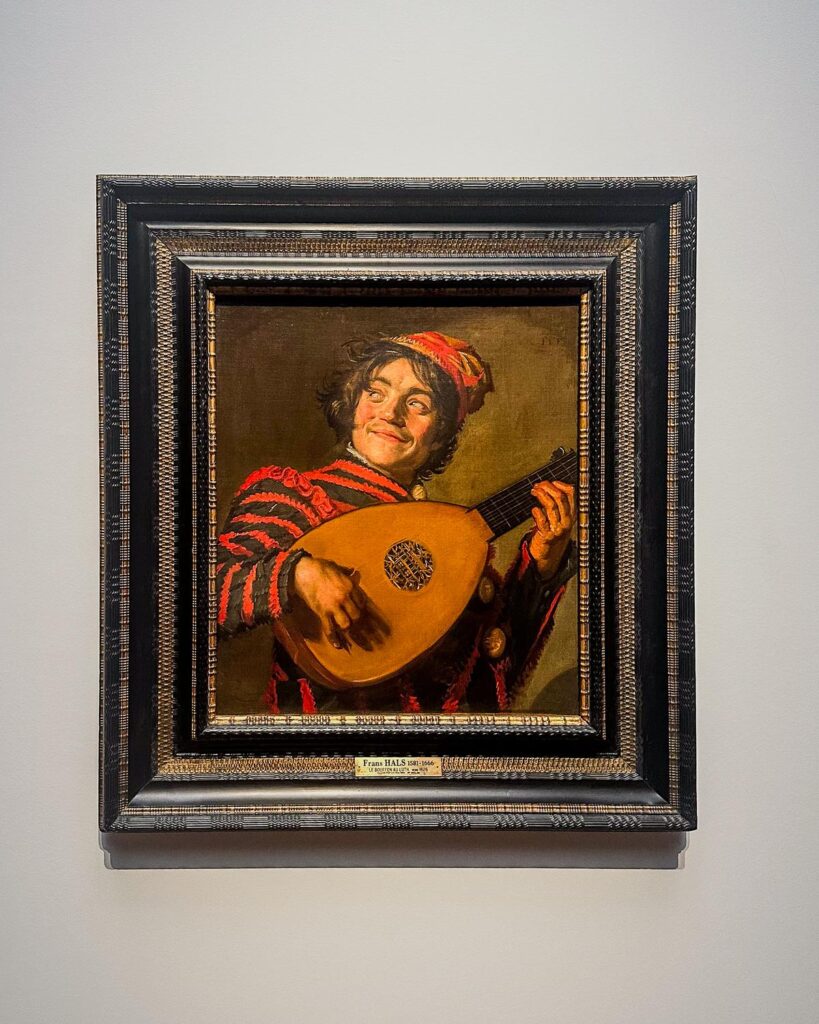 The Lute Player by Frans Hals - Baroque oil painting of a jovial lutenist in vibrant attire, displayed in museum